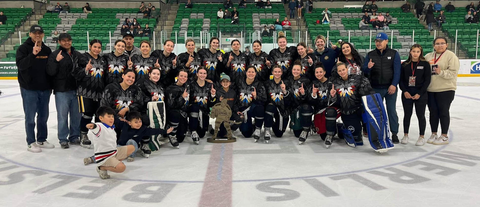 woman's hockey team gather for photo on the ice.