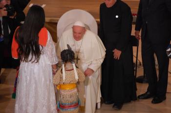Pope Francis accepts a gift from mother and daughter. 