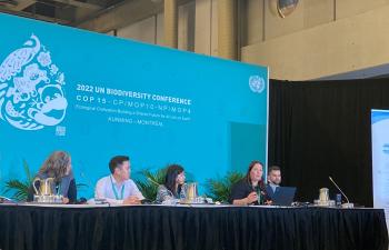 People sit at a table to present at COP15 in Montreal