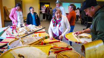 People gather to look at snowshoes and other crafts and handiworks.
