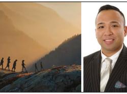 Two photos: At left is an image of people walking single-file over along the ridge of a mountain with mountains in a smokey mist layered behind the group. At right is a photo of a man in a suit and tie smiling at the camera.